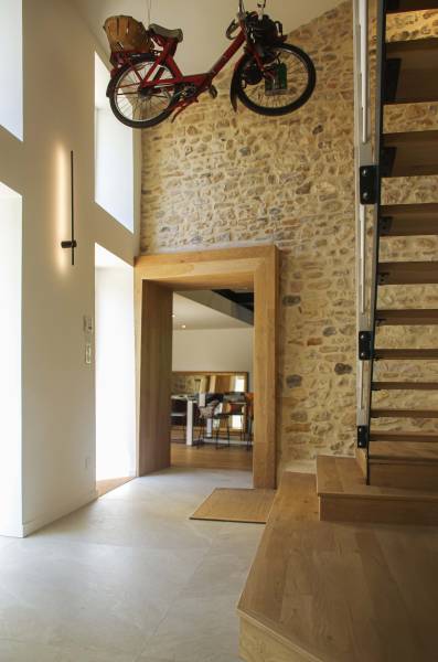 Ouverture entre les pièces de vie et l'entrée d'une grande maison dans le beaujolais